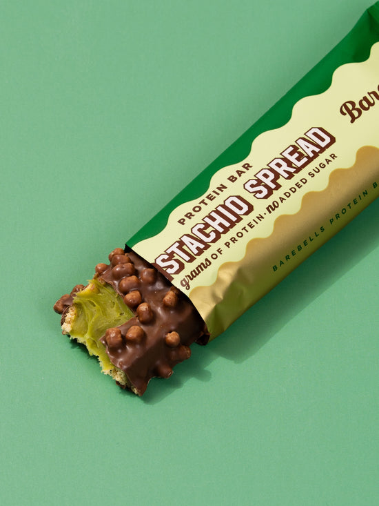 Single Barebells Pistachio Spread bar unwrapped showing pistachio filling and chocolate coating